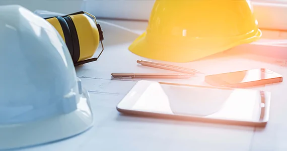 builders hat with tablet and pens on desk